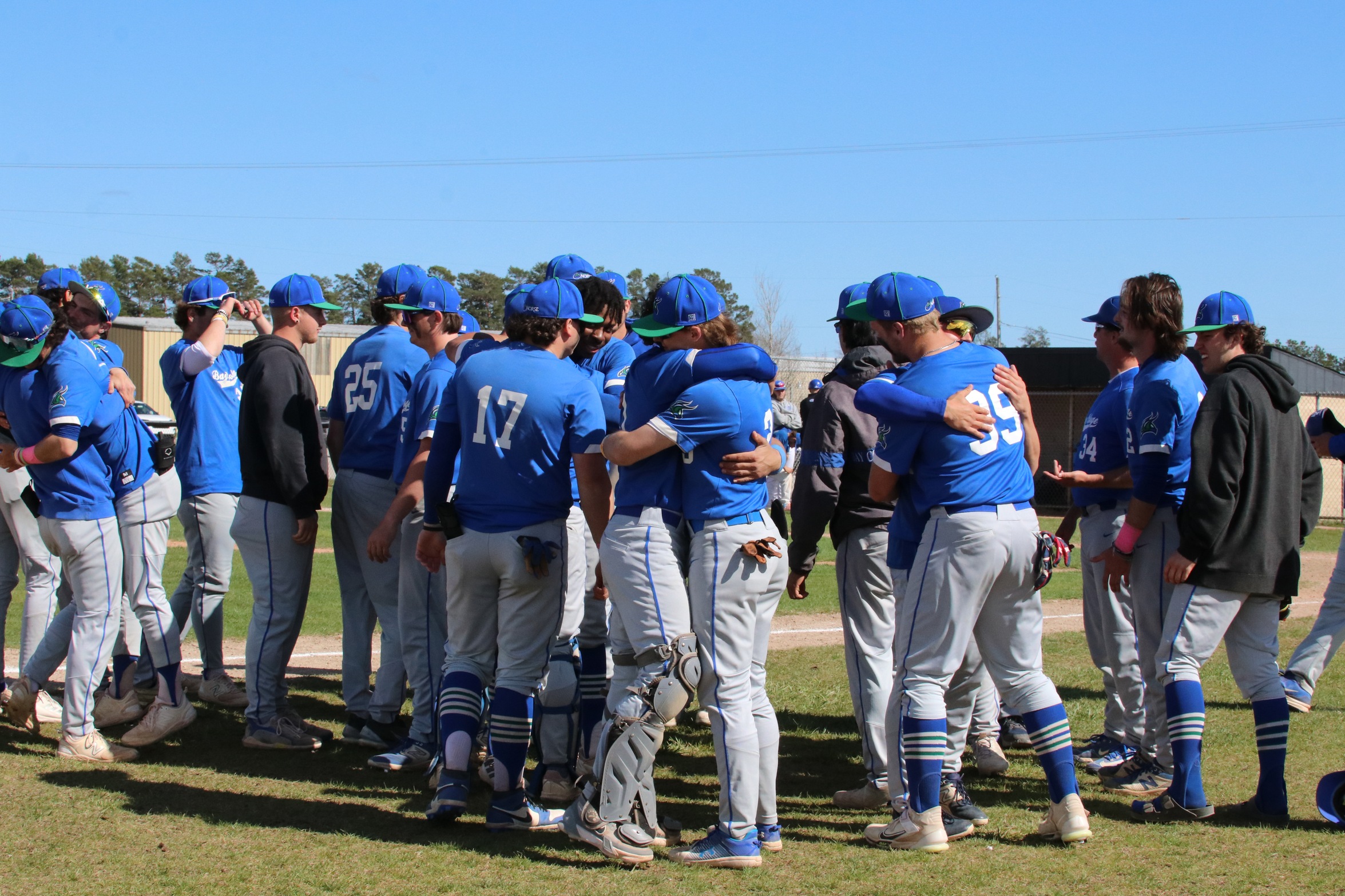 Several Bay players hugging and shaking hands after their final game of the season