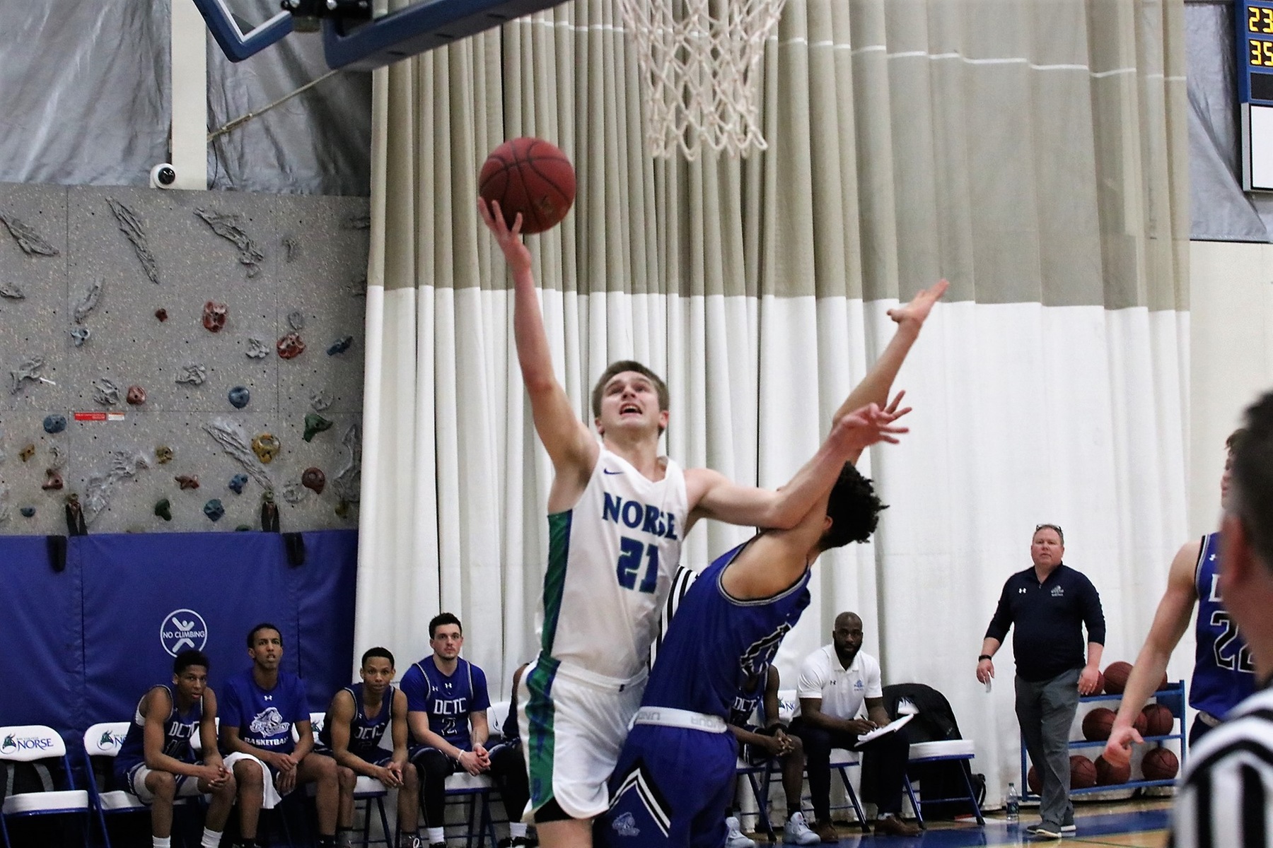 Tyler Willette extends the ball toward the rim with his right hand while is left arm holds off a defender