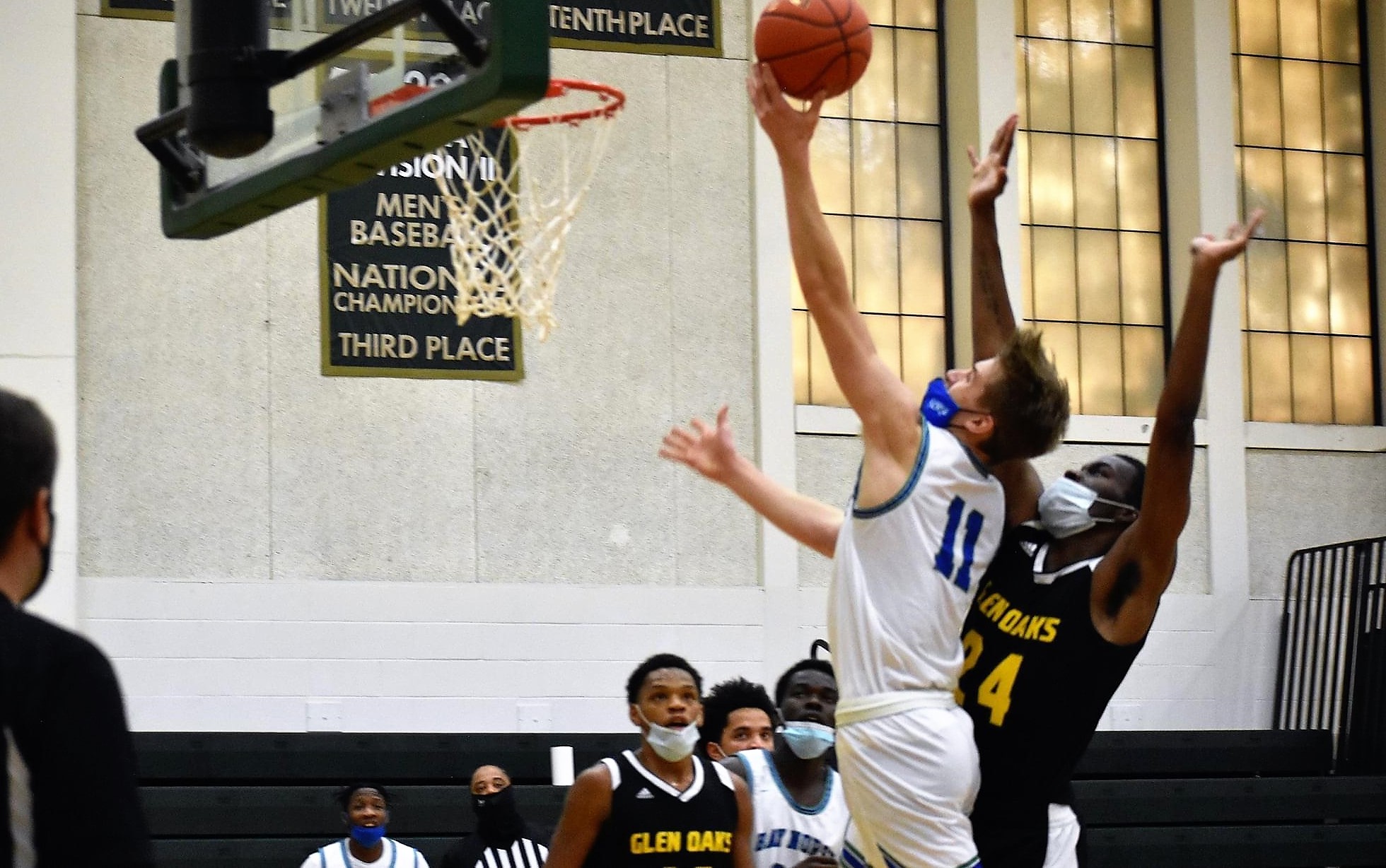 Ashton Janke releasing a shot at the rim with a defender behind him