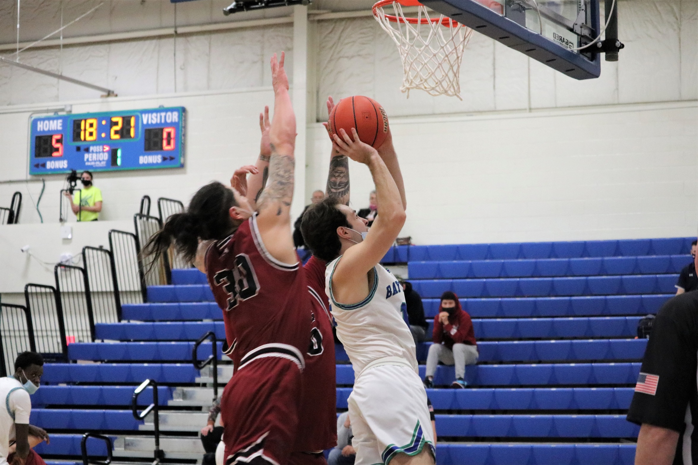 Matt Wagner going up for a shot under the basket with two defenders behind him bearing down