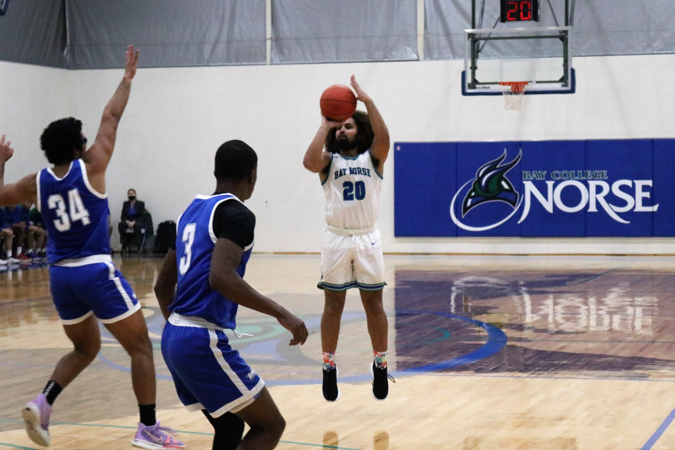 Marcus Harris in mid air about to release a three-point attempt