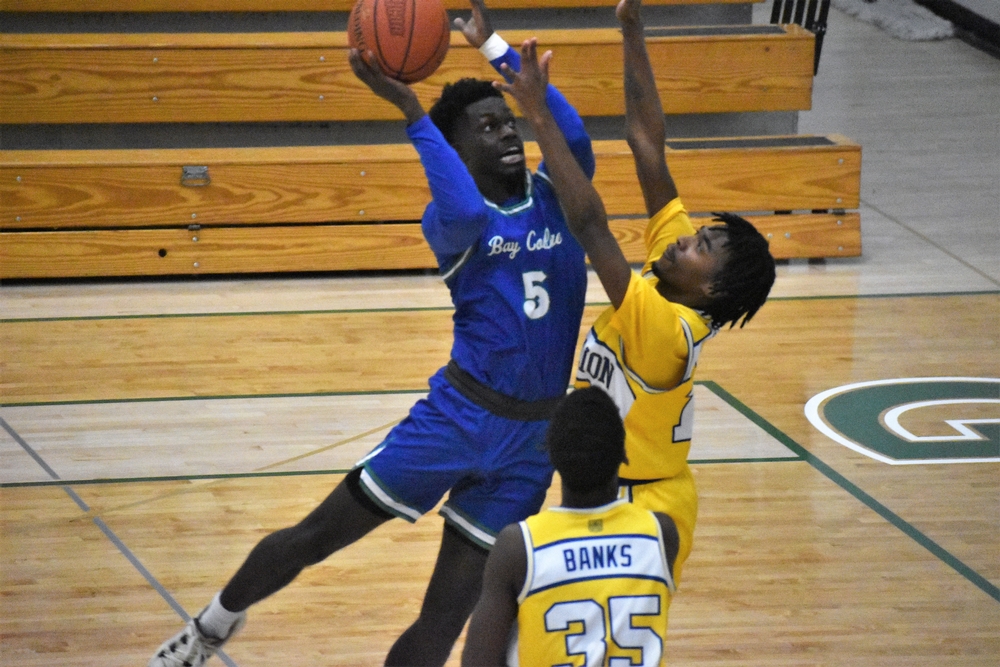Jaylen Flaniken in the lane going up for a shot as a defender reaches up