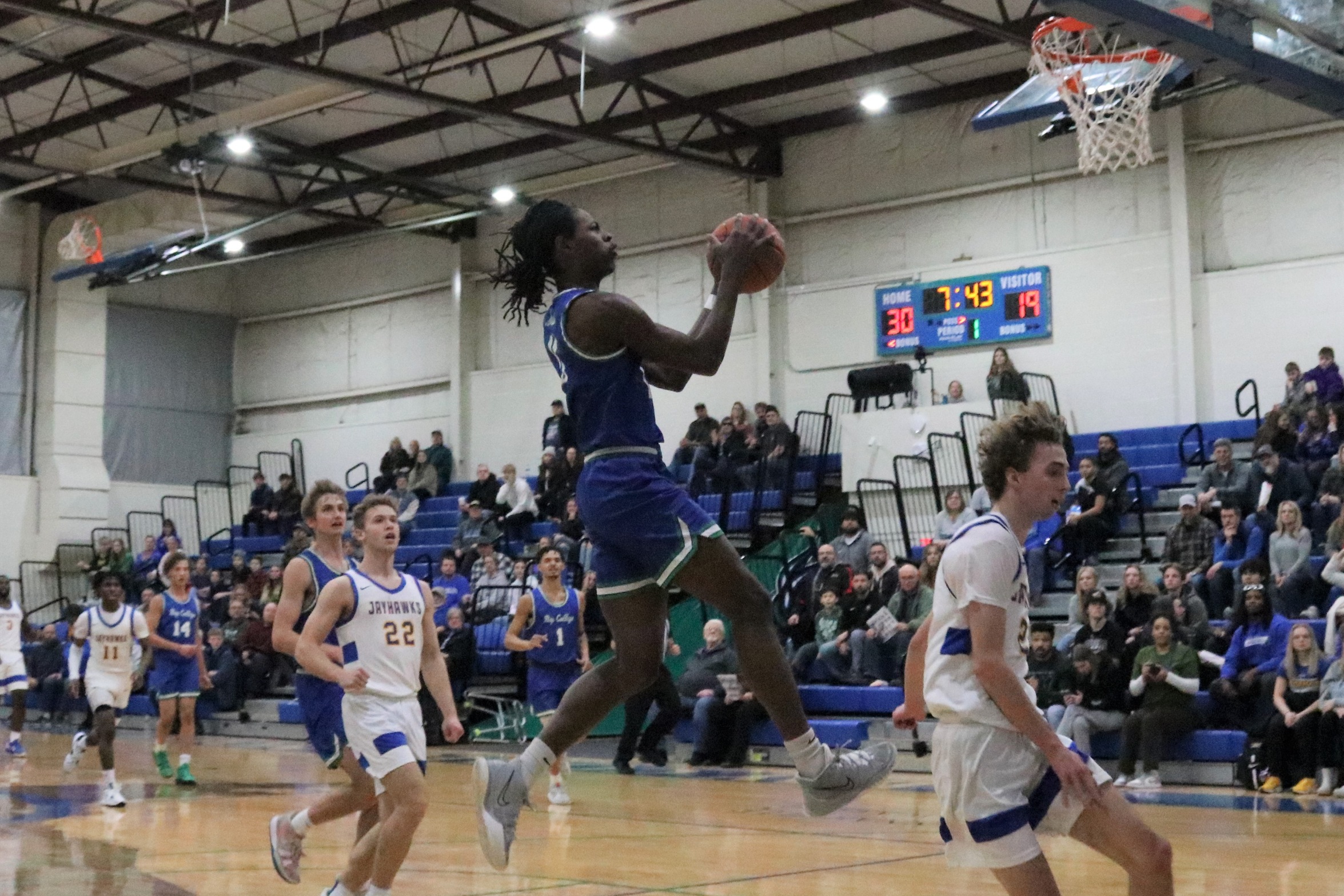 Genesis Kemp goes up for a fast break lay up as many players look on