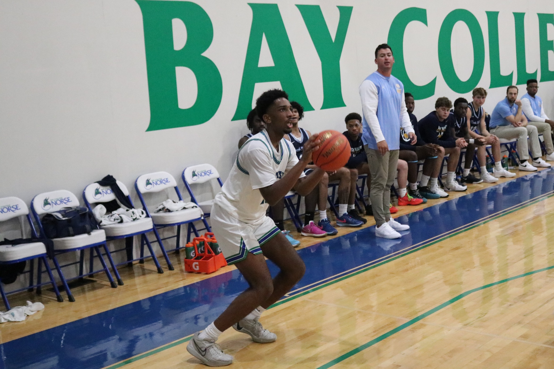 Nic Williams about to shoot a three in front of the opposing team's bench