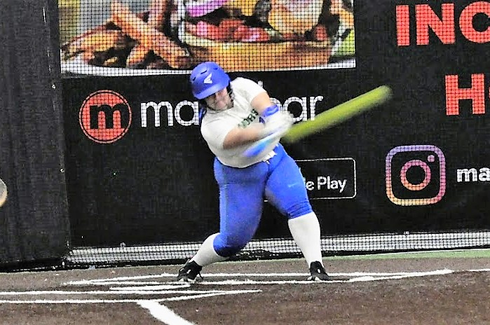 Allison Podhaniuk just after the point of contact as you see a yellow streak of the ball coming off her bat