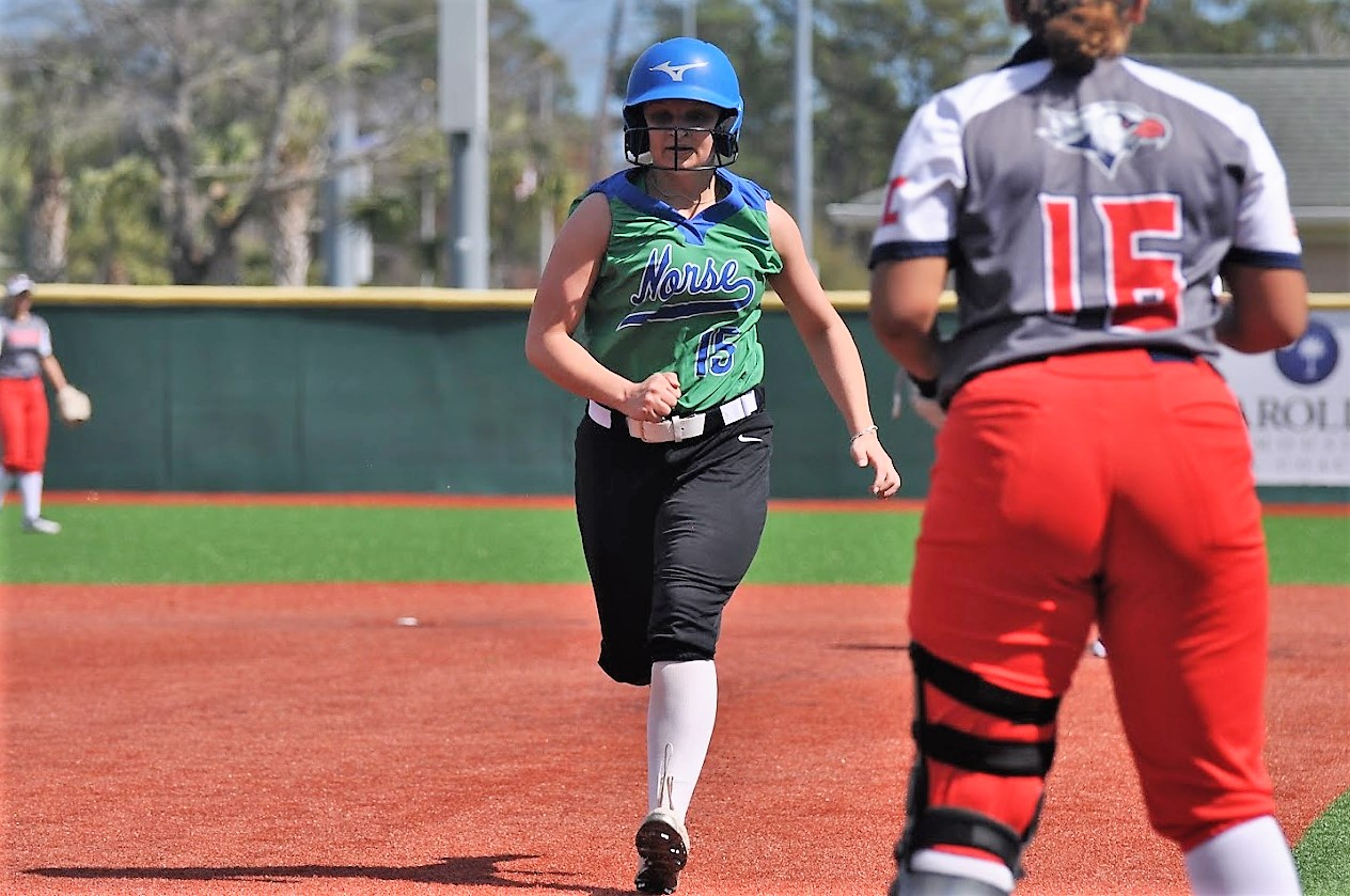 Lexi Kacalo moves to third base as the defender looks on