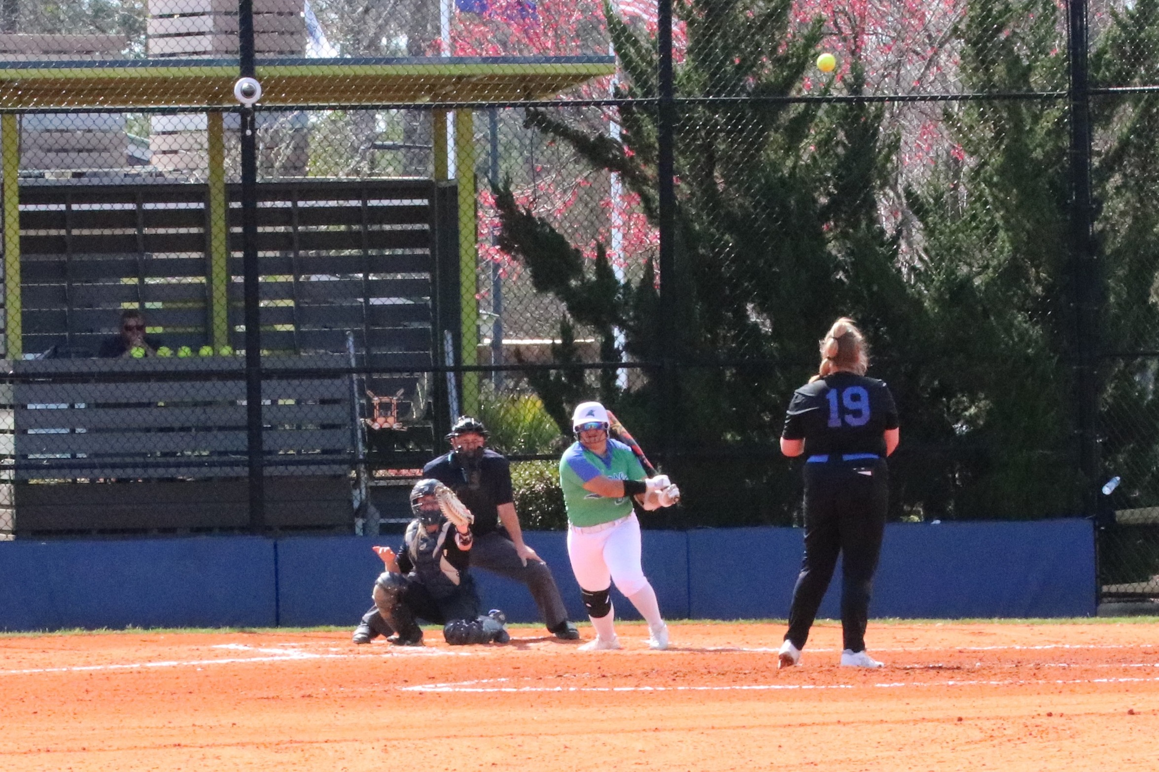 Dianne Salinas finishes her swing as the ball goes off her bat to center