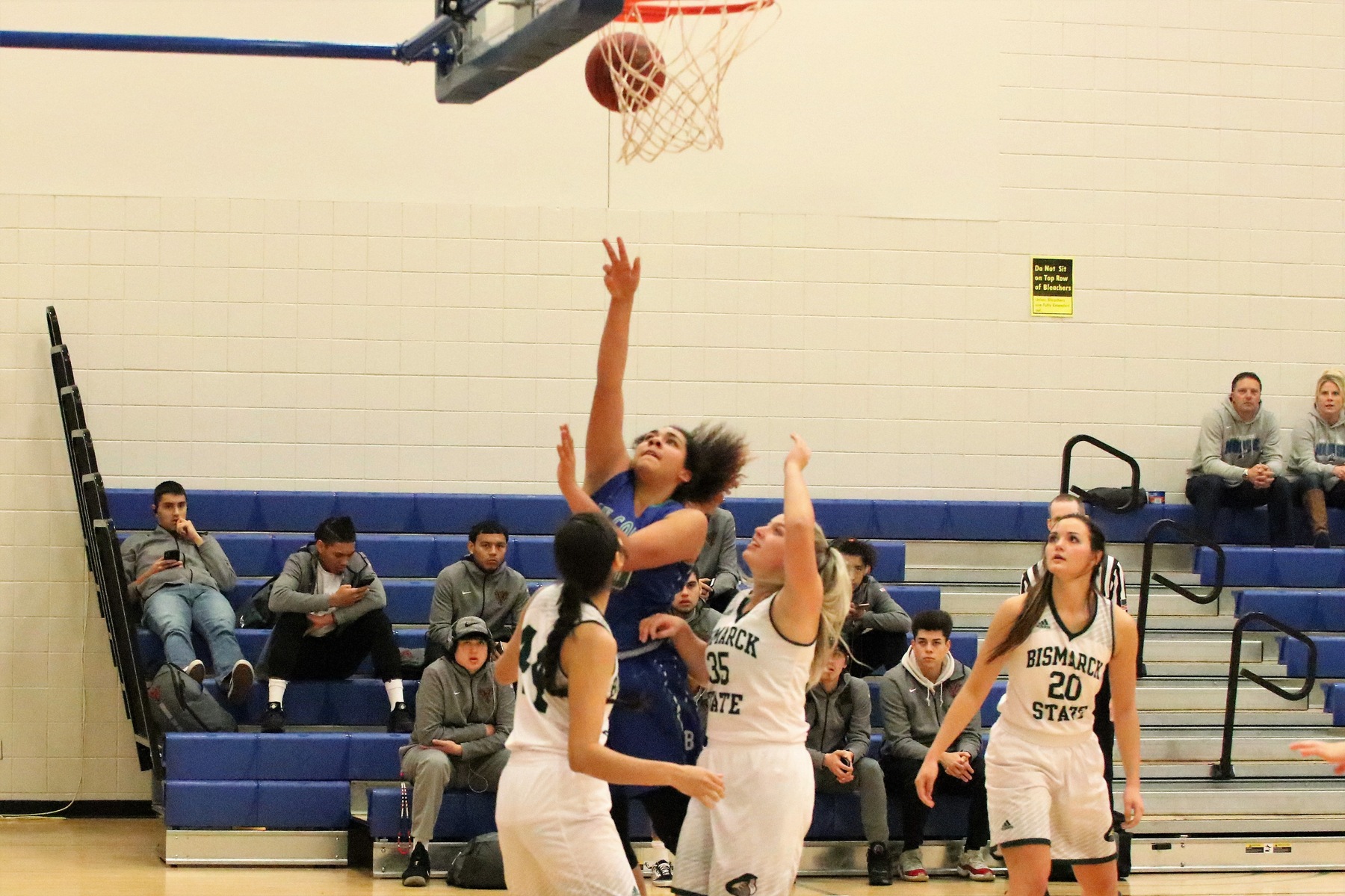 Keshia Davis shooting a shot near the rim amid two defenders