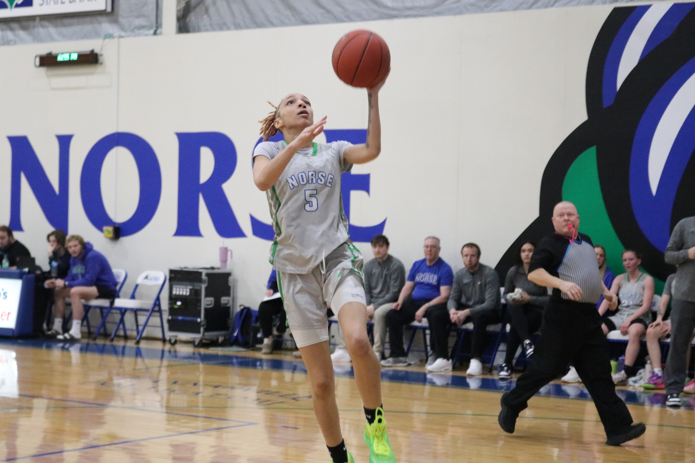 Ashlee Burchette going up for a left handed layup with the Bay bench looking on