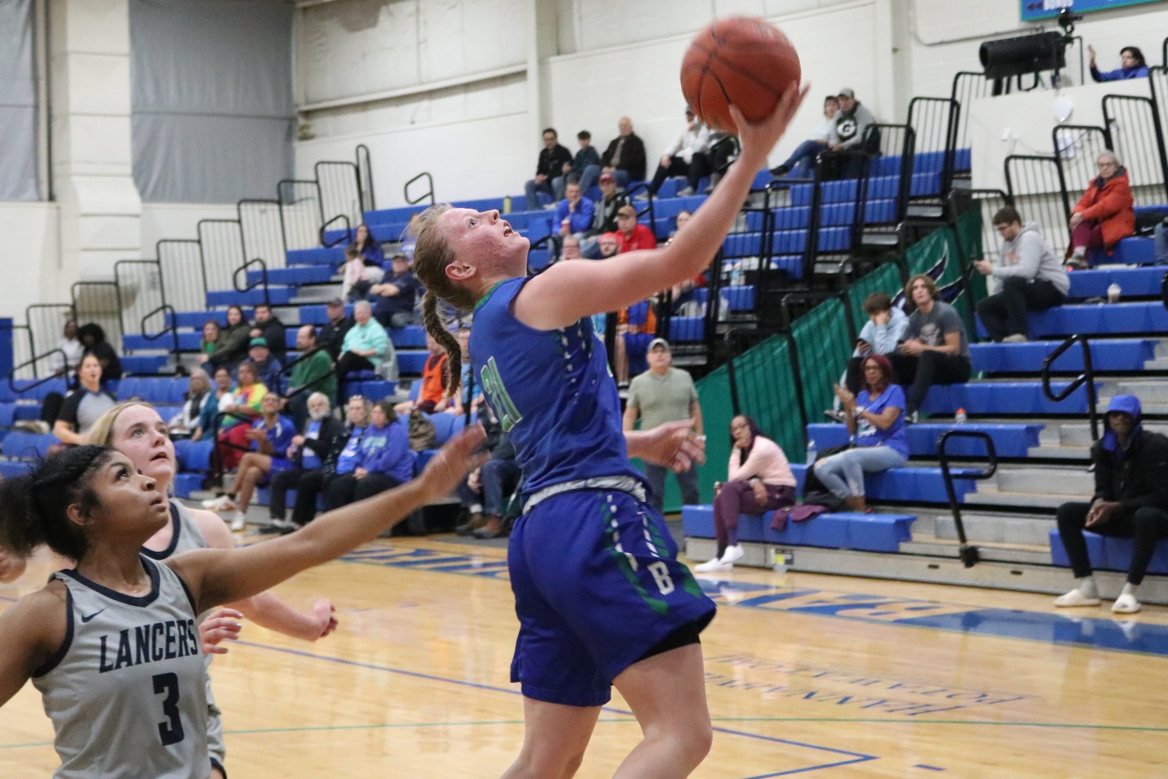 Siena Lingle about to release a layup as a defender trails her