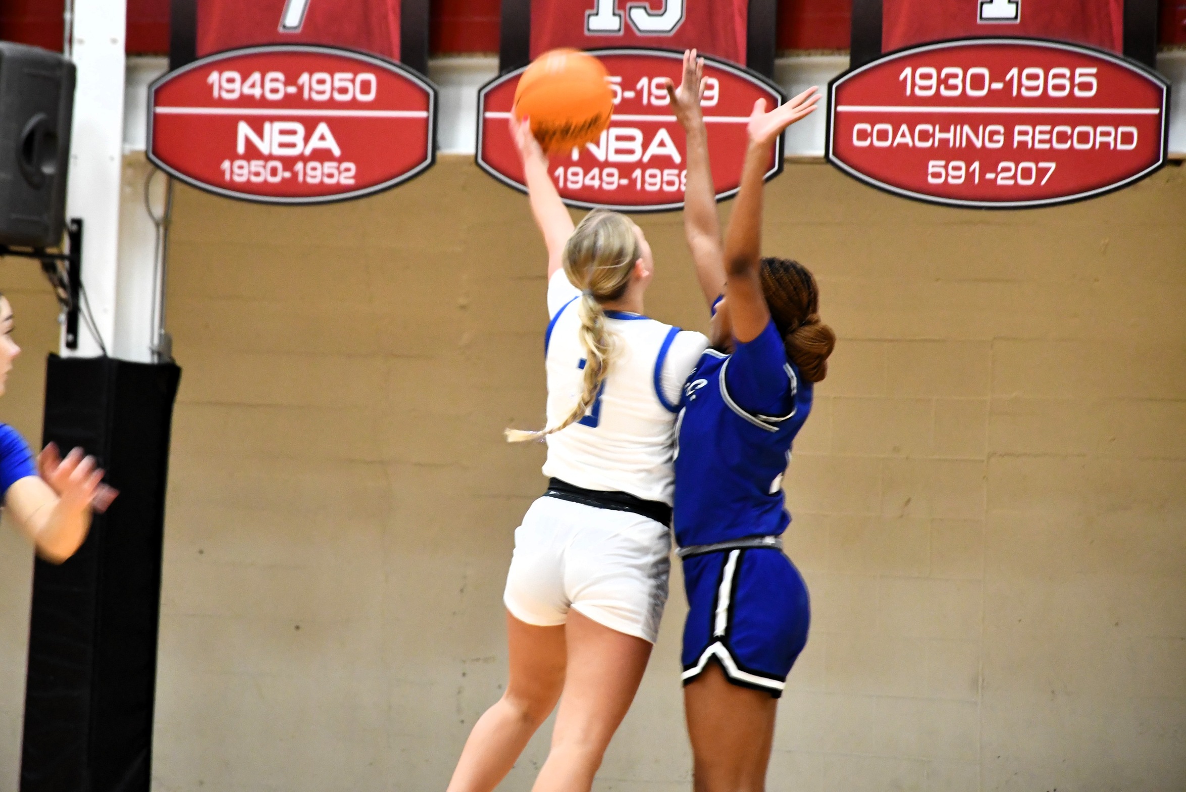 Anna Axtell going up for a layup as a defender positions herself between Anna and the basket