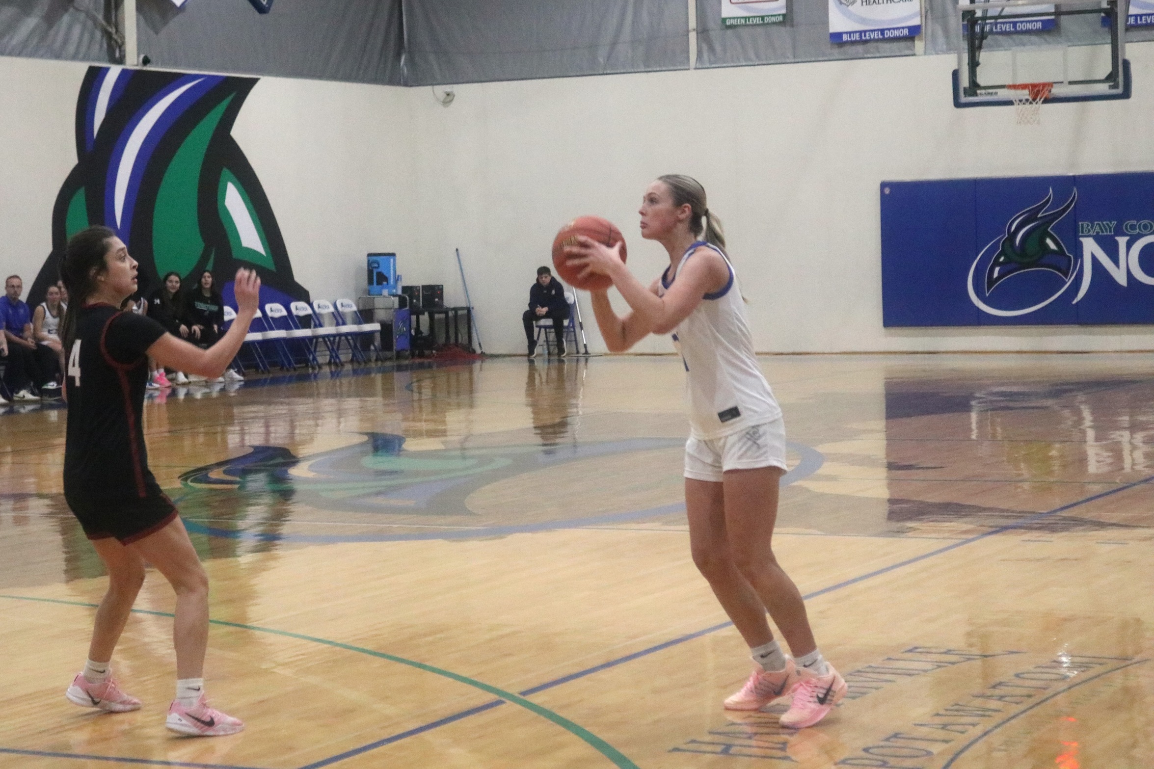 Jillian Fraser eyes up a three-point attempt while a defender closes in