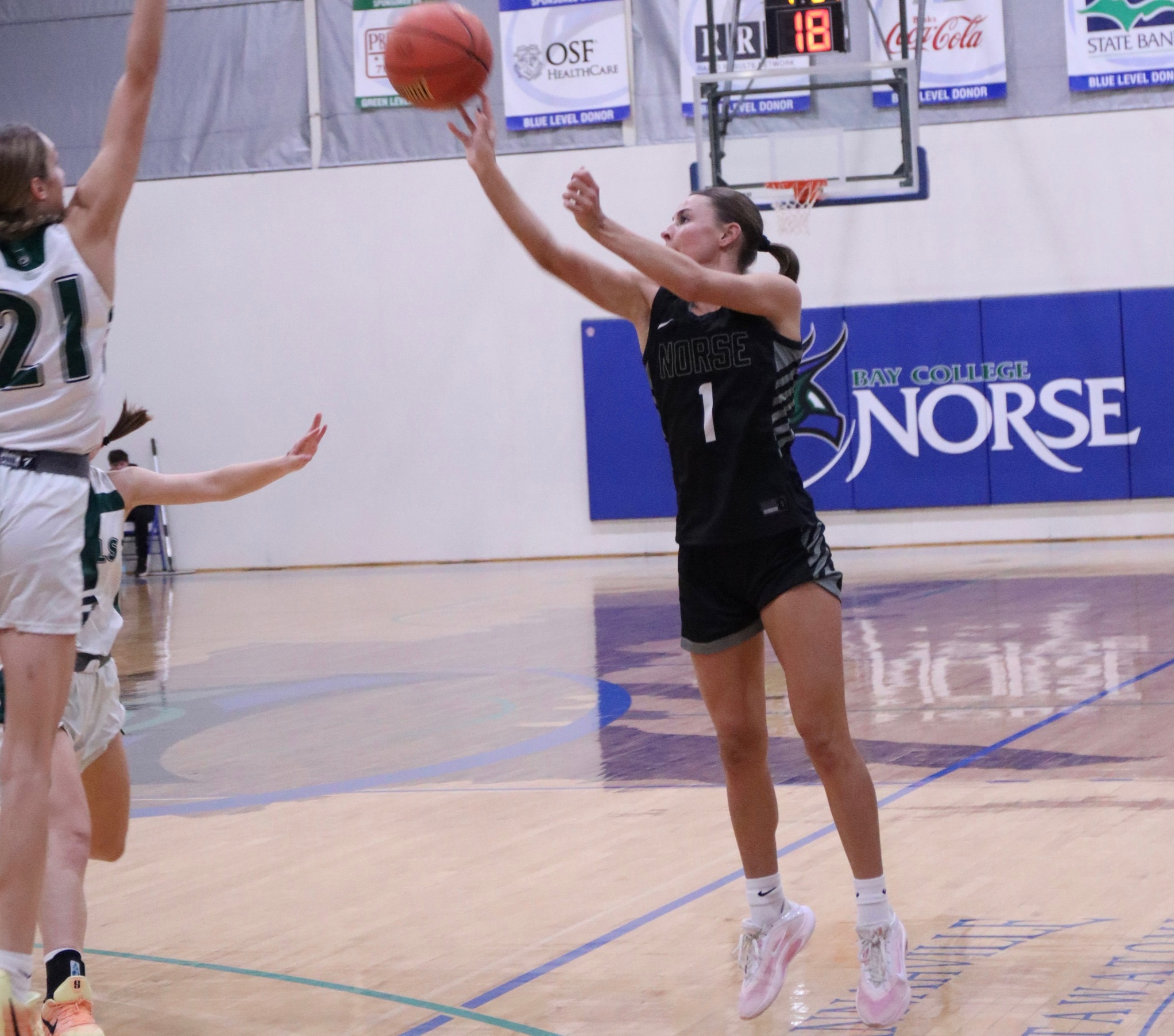 Makenna Hendrickson releases a three-point attempt as an opponent reaches up to close out