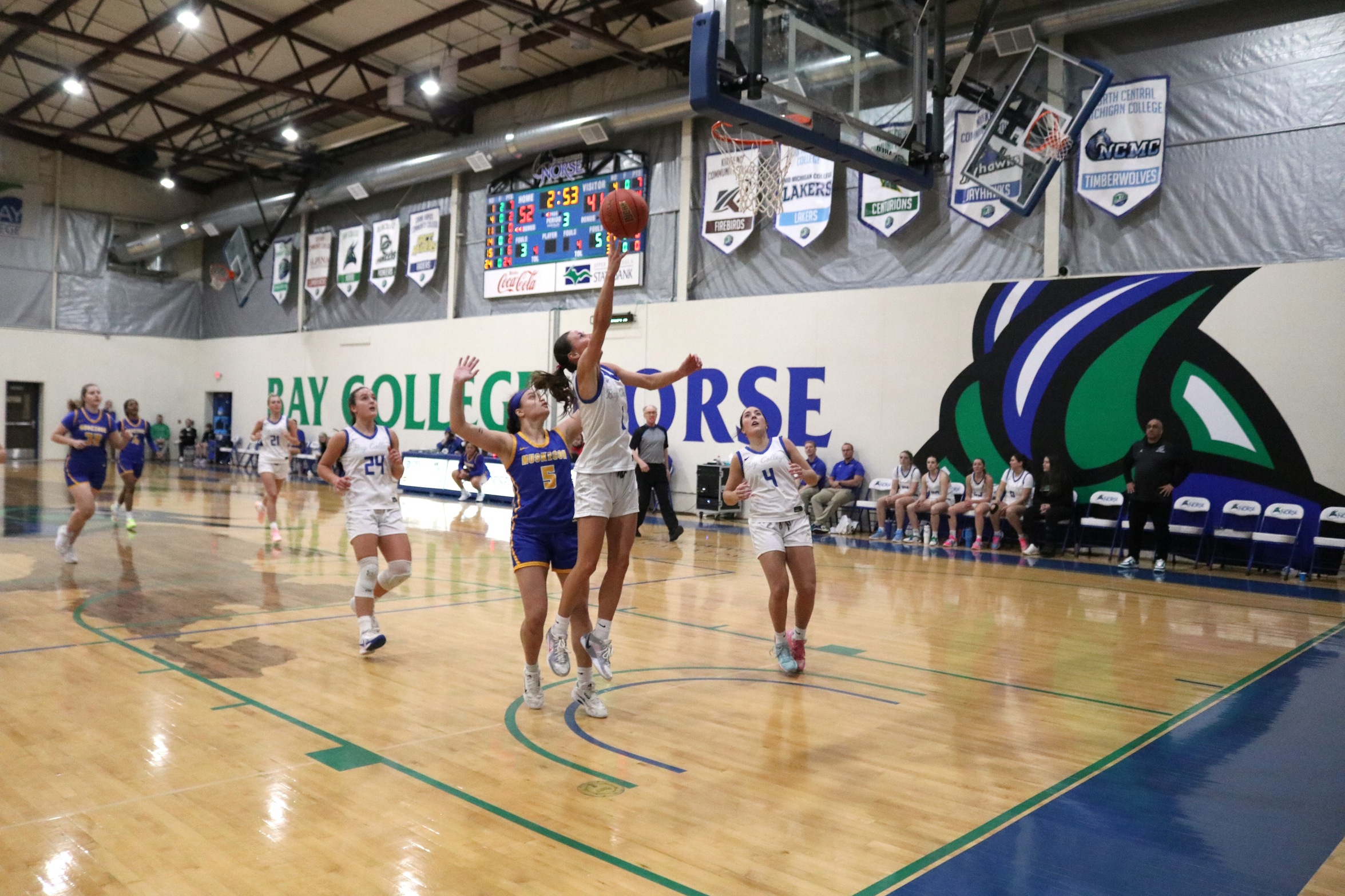 Makenna Hendrickson releases a layup as teammates and opponents chase from behind