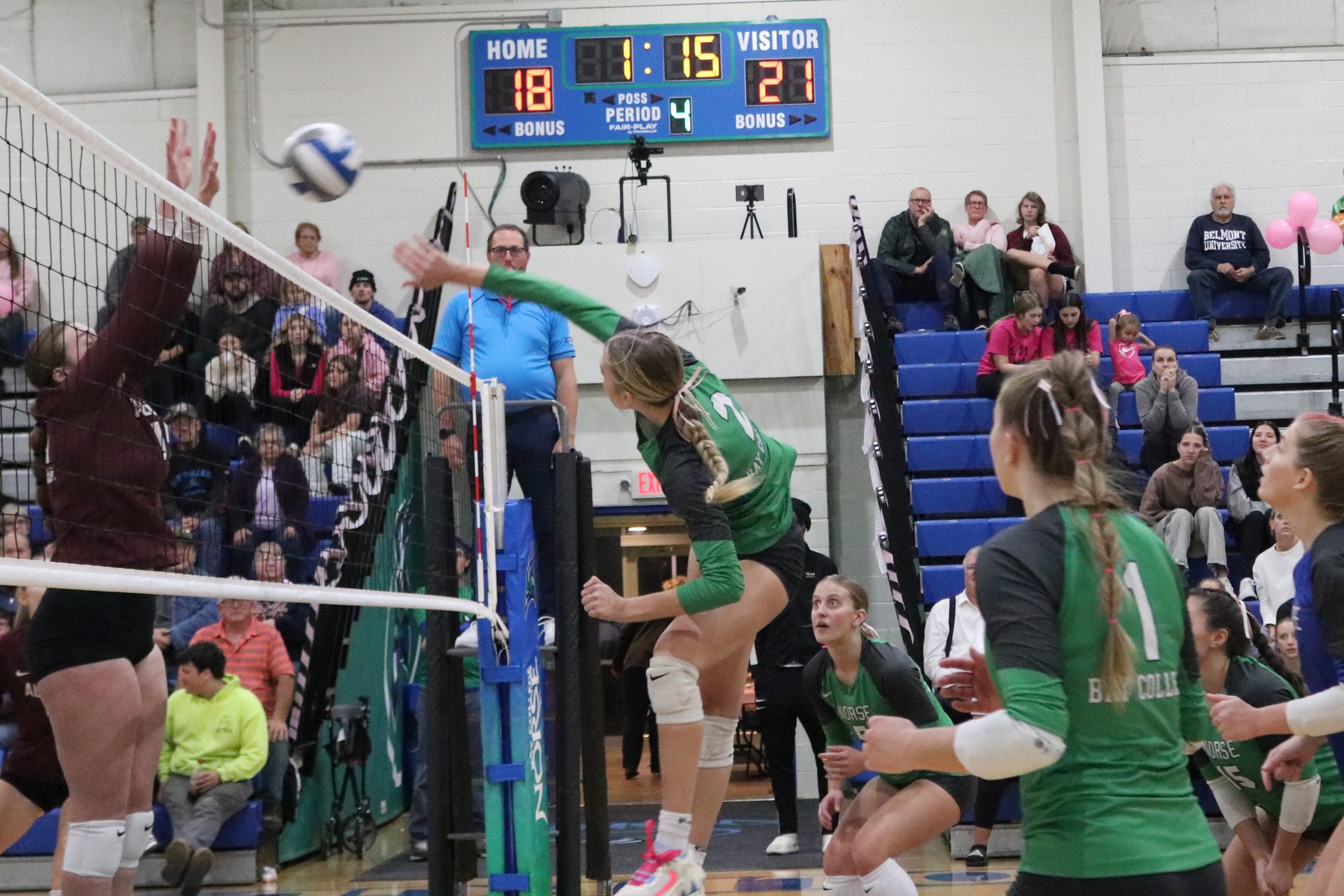 Piper Monroe finishing a swing for a kill as an opponent try to block