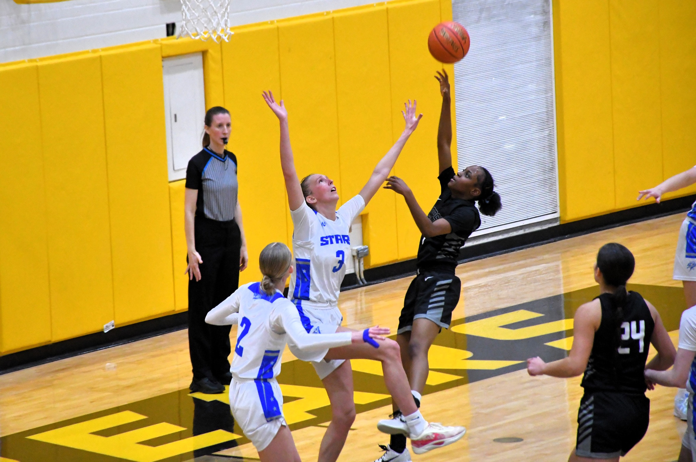 Anisa Longs puts up a shot in the lane as the defenders look on